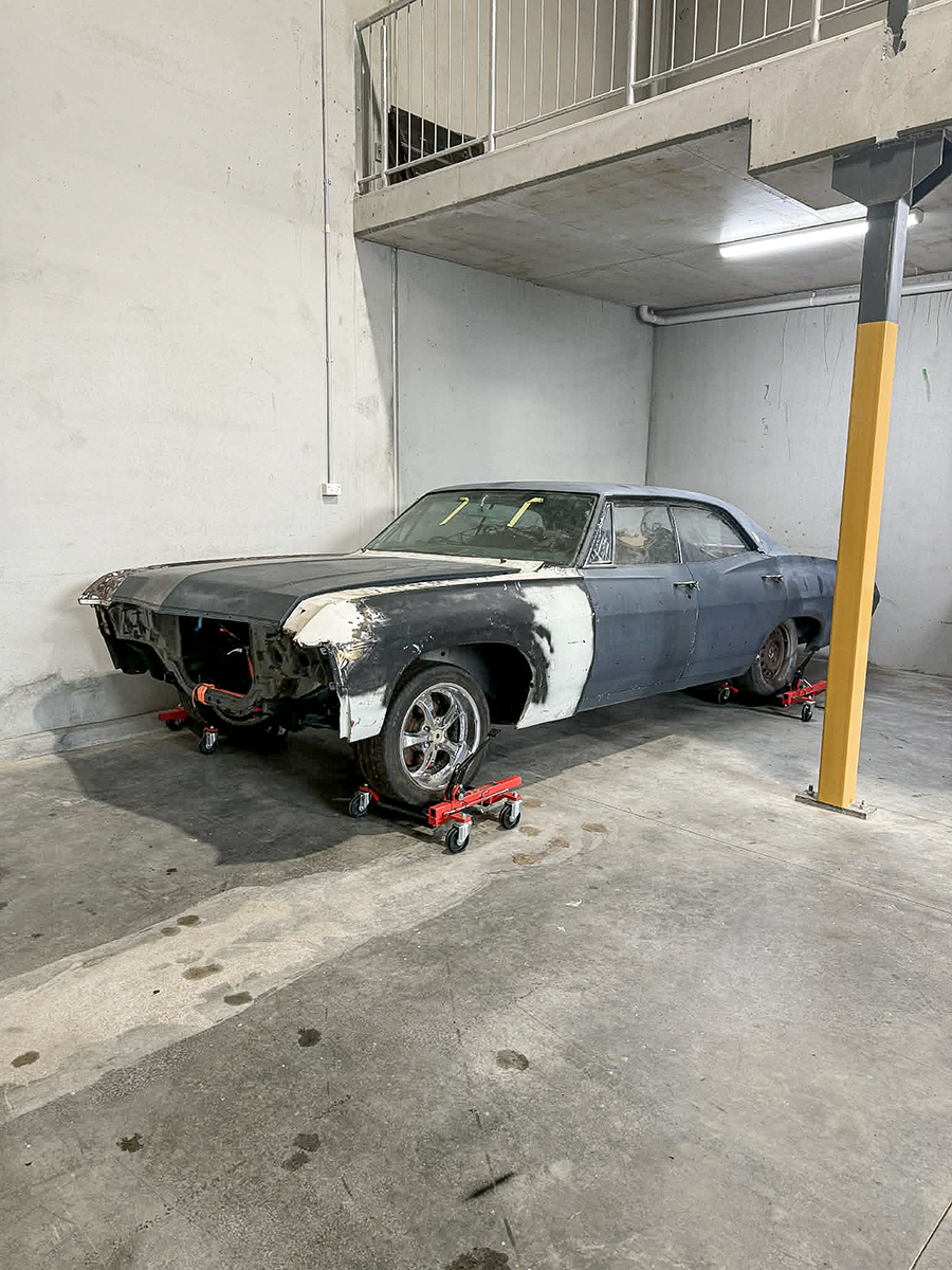 A classic car undergoing restoration in the space.