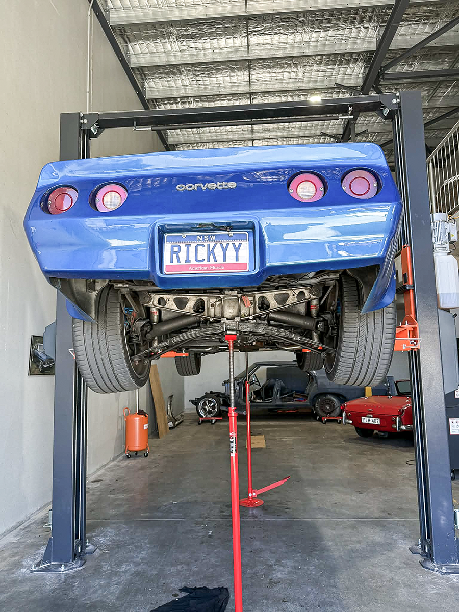 A rear view of a Corvette on the hoist.